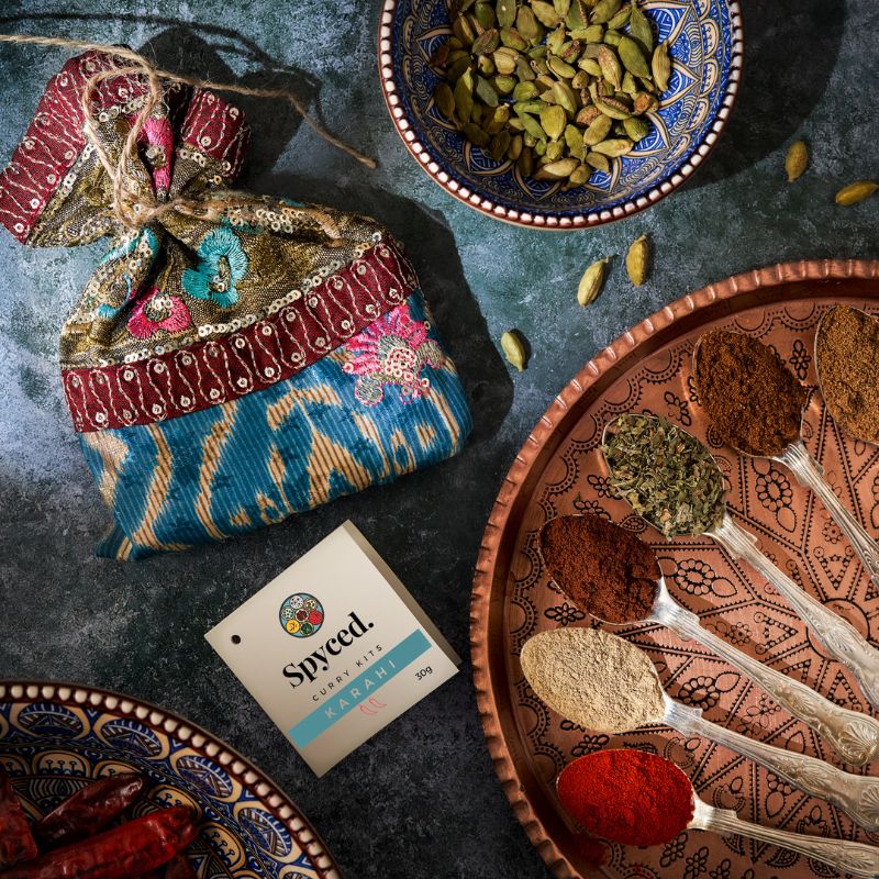 A Spyced gift bag and colourful Karahi spices displayed in teaspoons